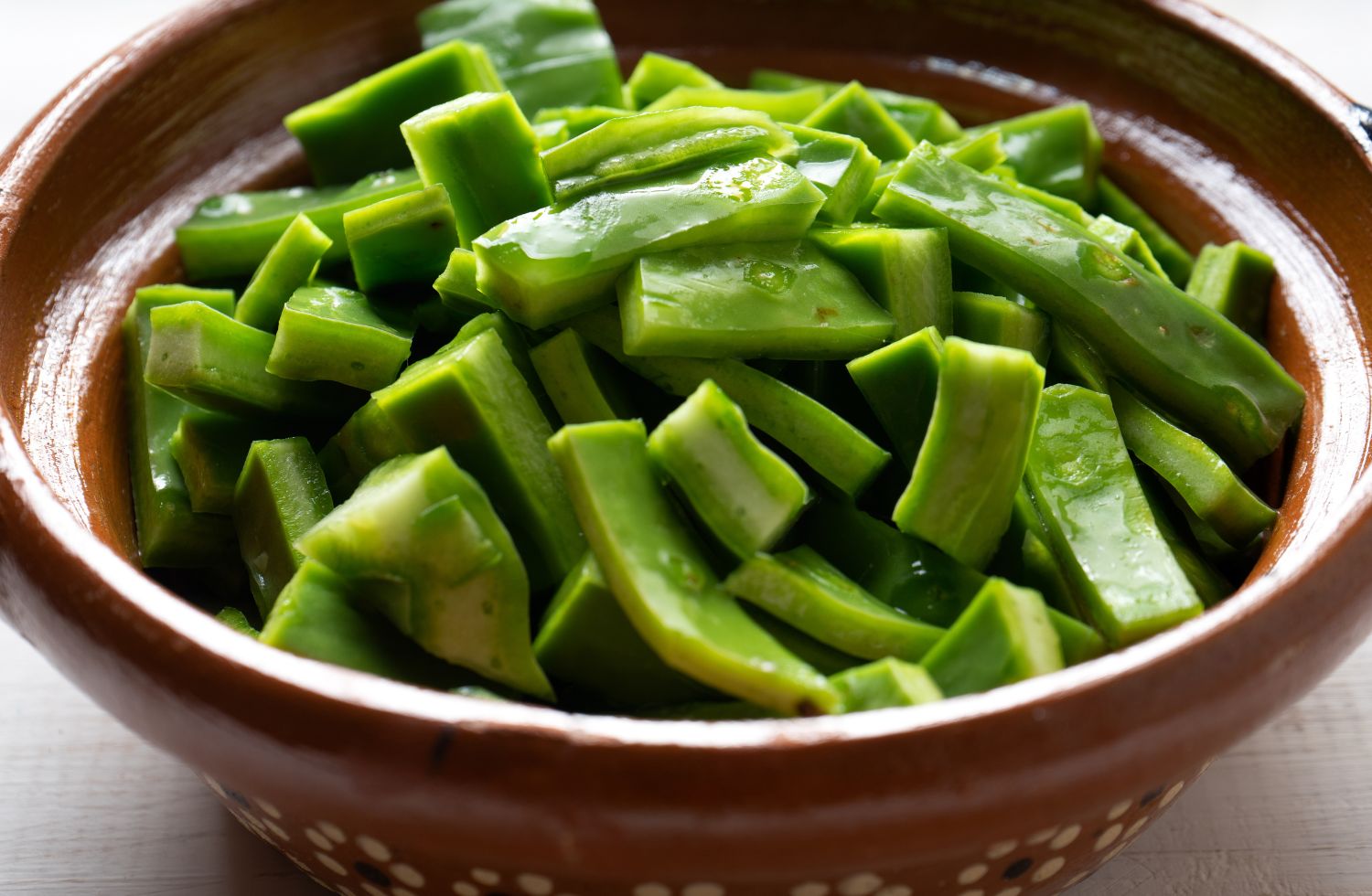 Nopales cortados en un tazón con sal de grano, un método efectivo sobre cómo quitar la baba a los nopales.