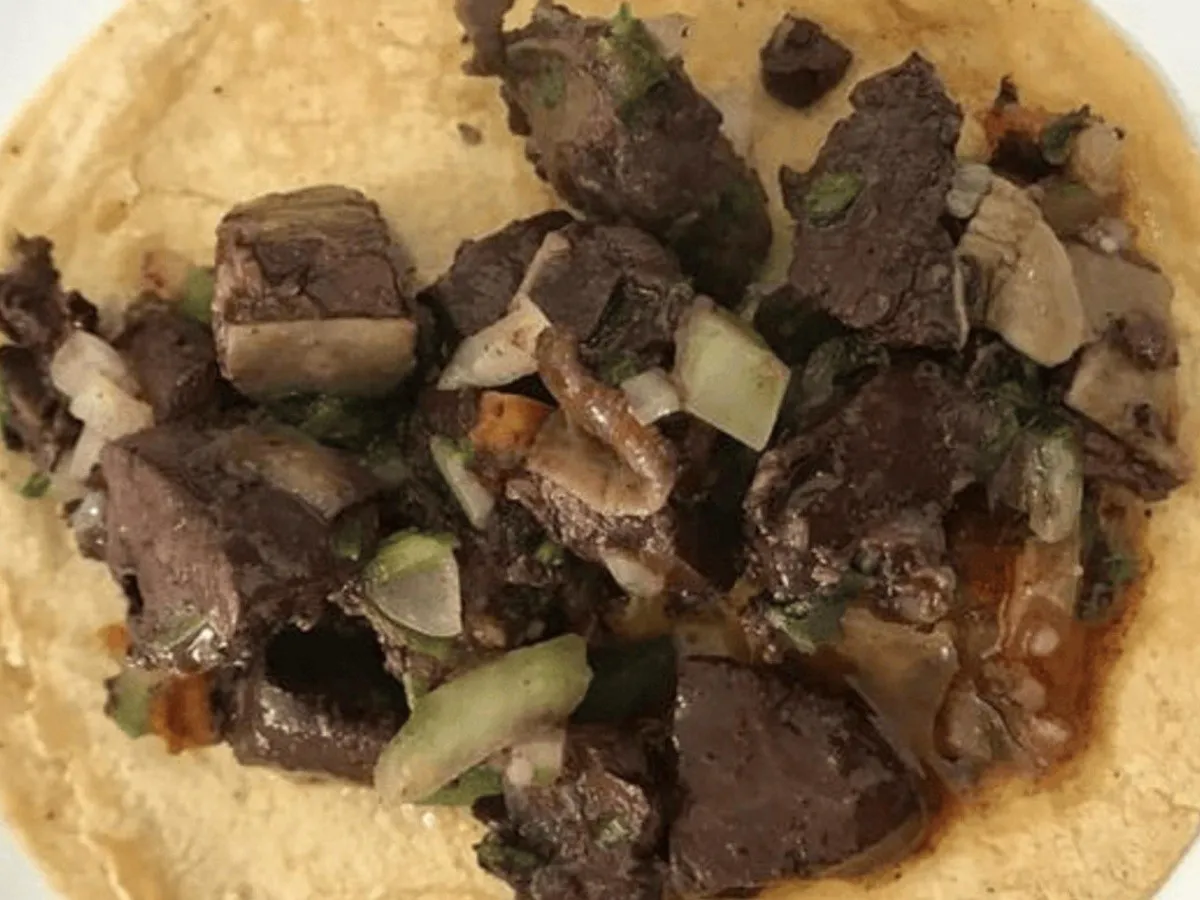 Un plato con moronga frita y cebolla, mostrando qué tan saludable es este tradicional embutido.