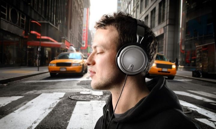 Una persona con auriculares disfrutando de la música en su smartphone, explorando las mejores alternativas gratis a Spotify.