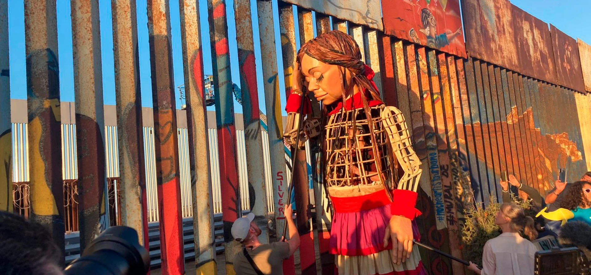 Amal la marioneta junto a logos de agencias de la ONU, destacando el apoyo internacional a su misión.