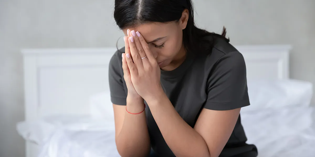 Persona rezando con las manos juntas, simbolizando el origen religioso de 'andar con el Jesús en la boca'.
