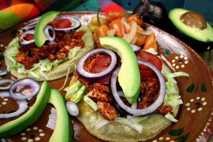 Plato de salbutes yucatecos con pavo deshebrado y cebolla morada, un platillo tradicional de Yucatán.