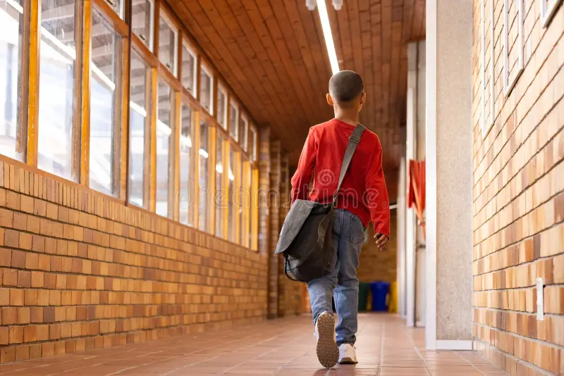 Un niño con mochila caminando hacia la escuela, representando la asistencia a la última semana de clases SEP.