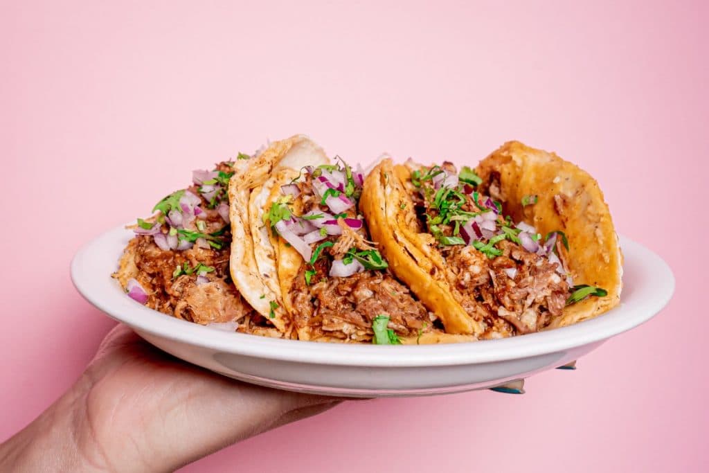 Un plato de birria tradicional con consomé y tacos, una de las mejores opciones para comer birria en CDMX.