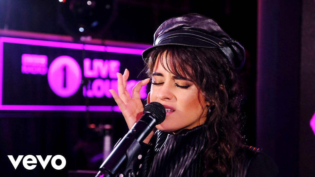 Camila Cabello cantando en un escenario, representando su éxito profesional en paralelo a su vida amorosa.