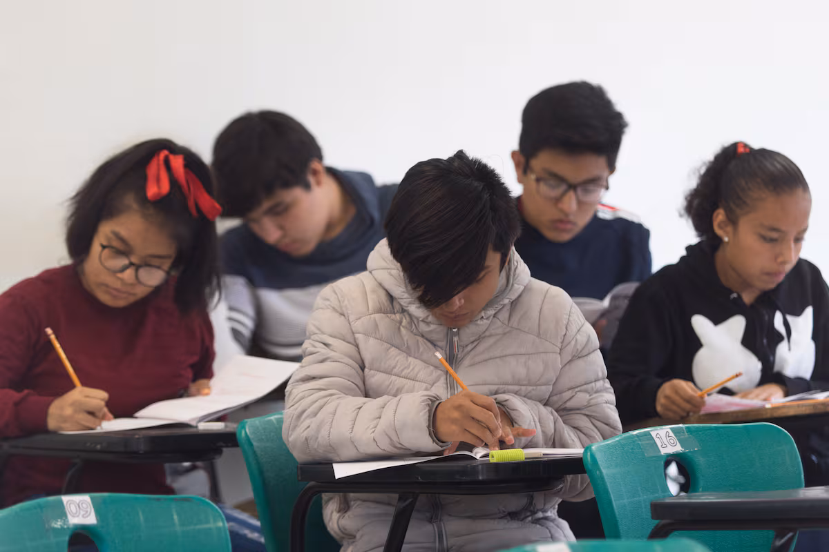 Estudiantes de secundaria sonriendo en un aula, motivados por la oportunidad de la Beca Rita Cetina.