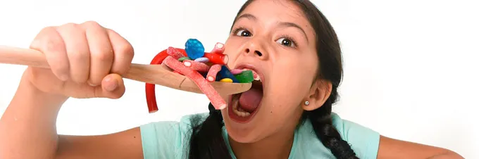 Niños sonriendo mientras disfrutan de dulces mexicanos, mostrando la alegría que generan estos productos.