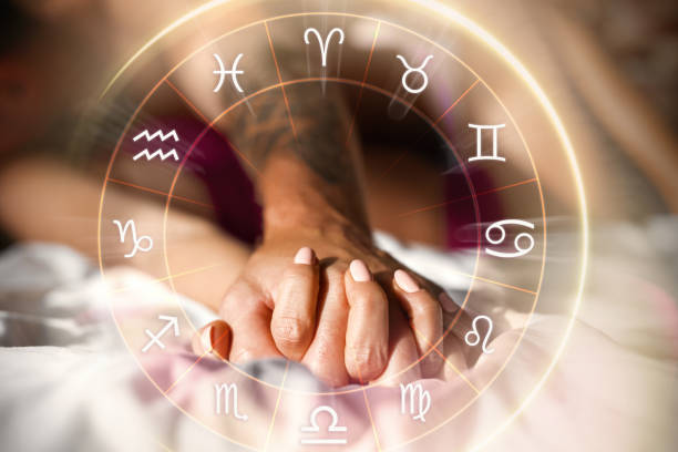 Pareja tomada de la mano con símbolos zodiacales, representando a los signos zodiacales más fieles en el amor.