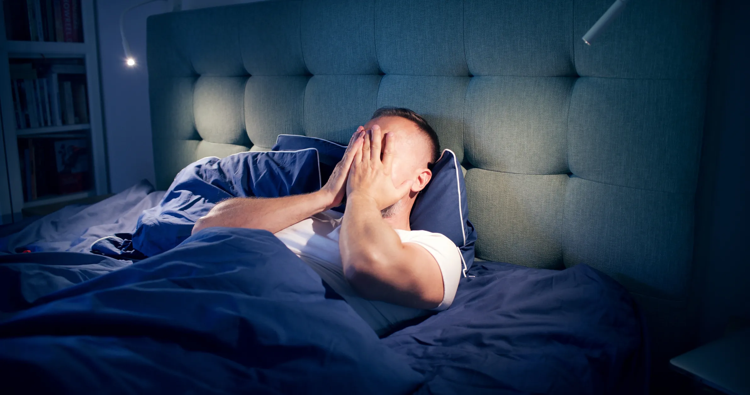 Persona en la cama, reflexionando después de una pesadilla, buscando mejorar su descanso y bienestar.