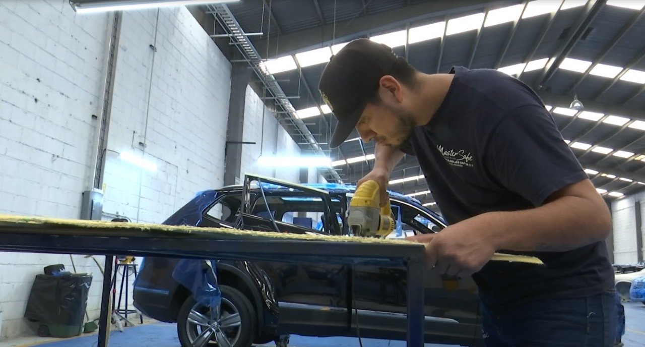 Taller especializado en blindaje automotriz, con técnicos trabajando en un auto.