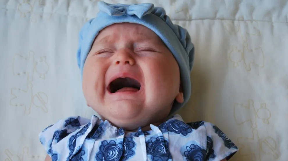 Bebé llorando, una señal de que los adornos le están causando molestias o dolor.