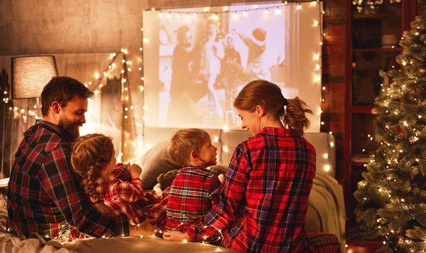 Familia viendo películas de Navidad 2025 juntos en la sala, con adornos festivos.