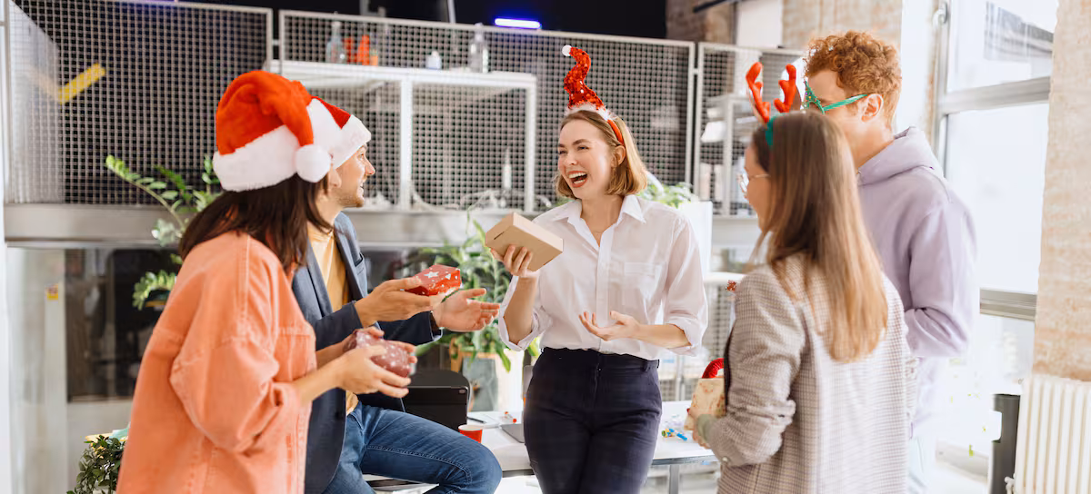 Grupo de amigos celebrando la Navidad con regalos, facilitado por el uso de apps Amigo Invisible.