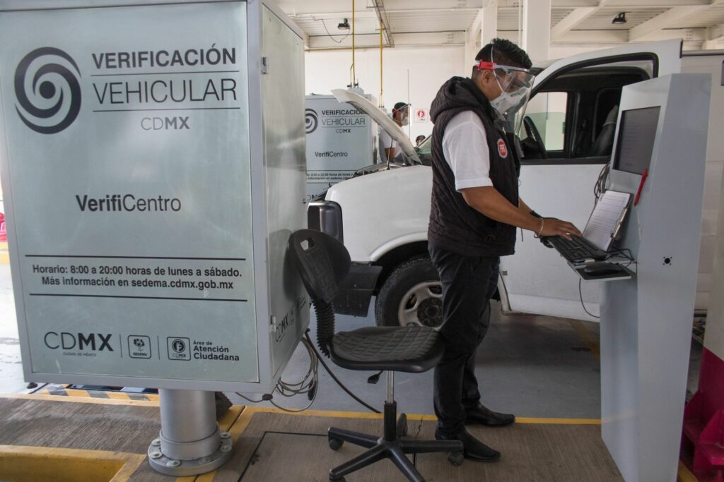 Persona pagando en un verificentro, ilustrando los costos y multas de la verificación vehicular CDMX.