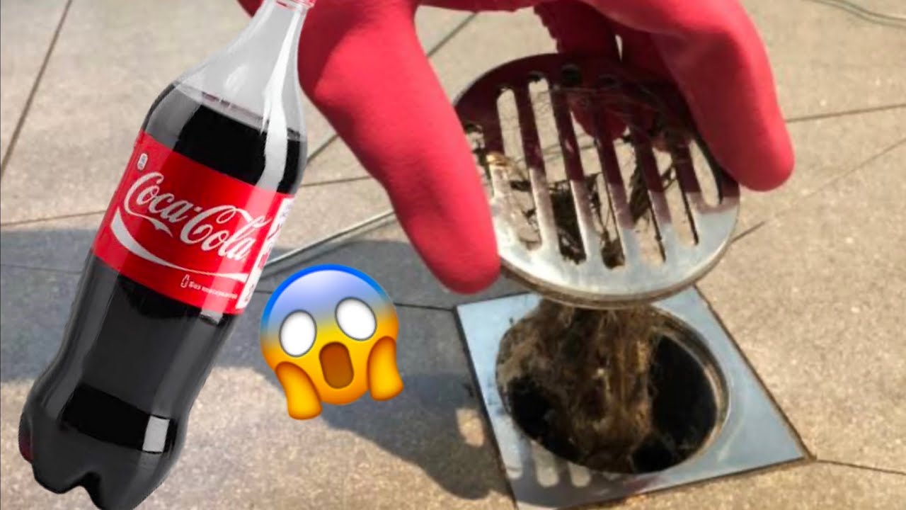 Botella de refresco de cola cerca de un inodoro, para usar en el truco de destapar.
