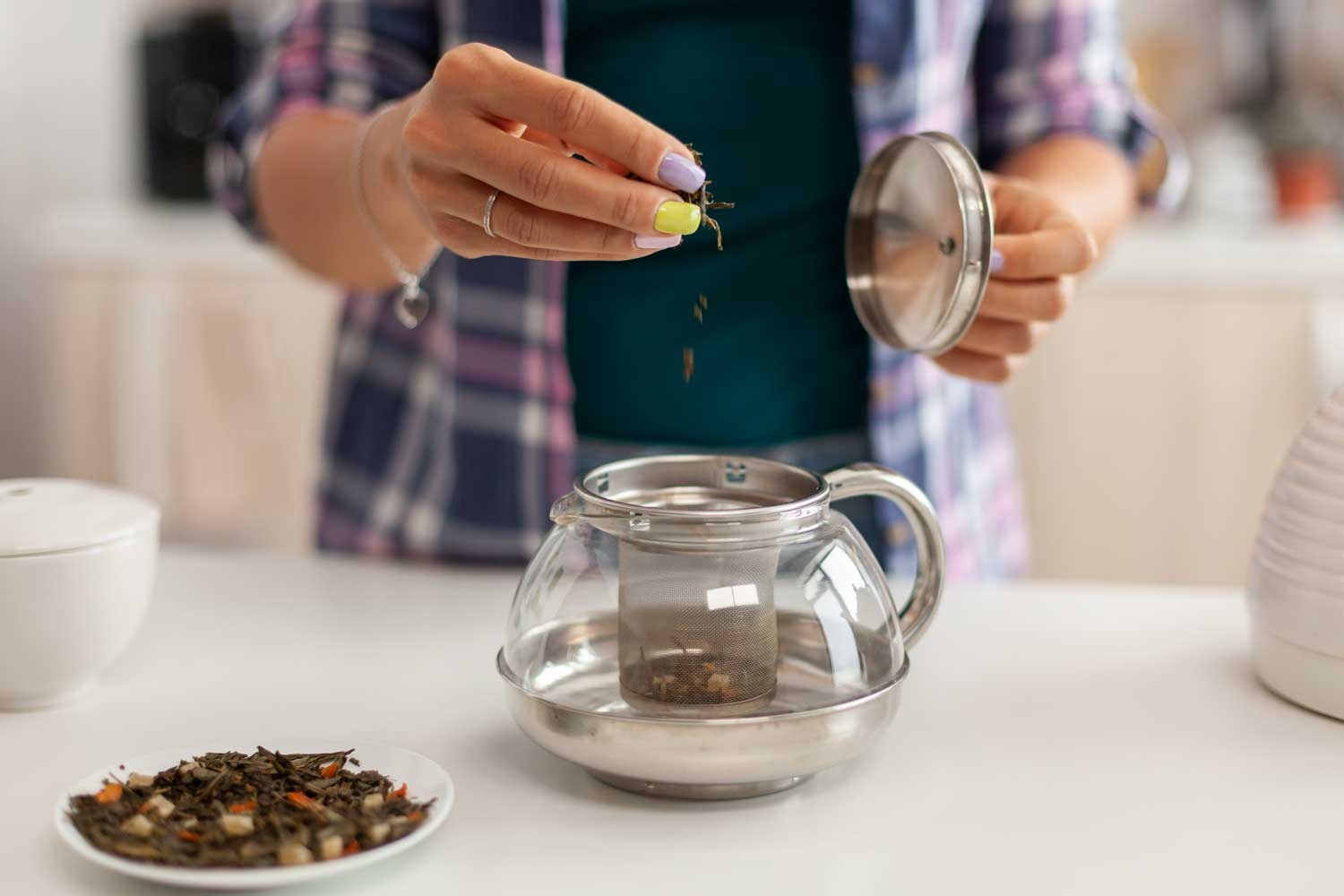 Manos preparando té de abango, siguiendo los pasos para una infusión correcta.