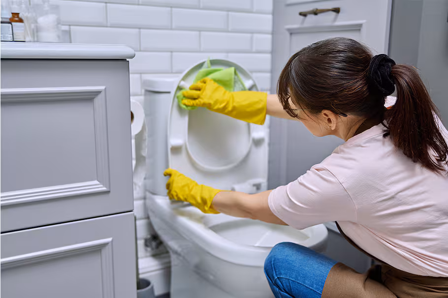 Un baño con inodoro y azulejos brillantes, resultado de limpiar con bicarbonato y vinagre.