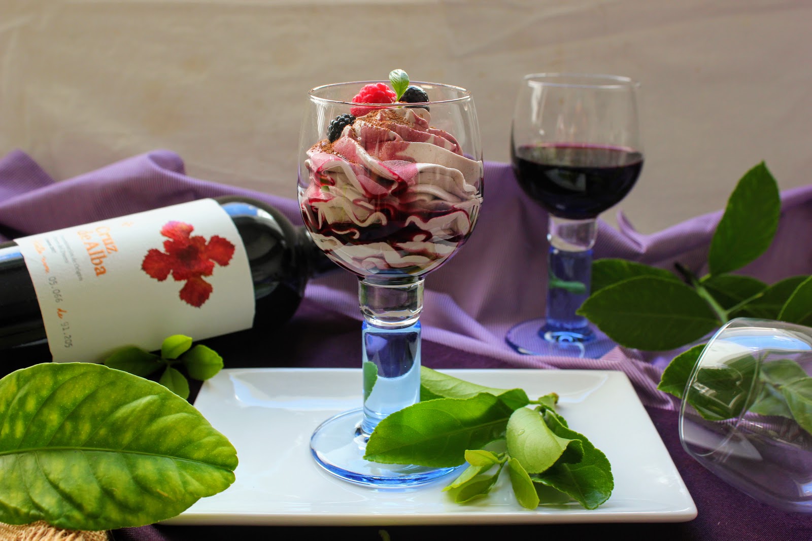 Un postre navideño con frutos rojos maridado con una copa de vino dulce.