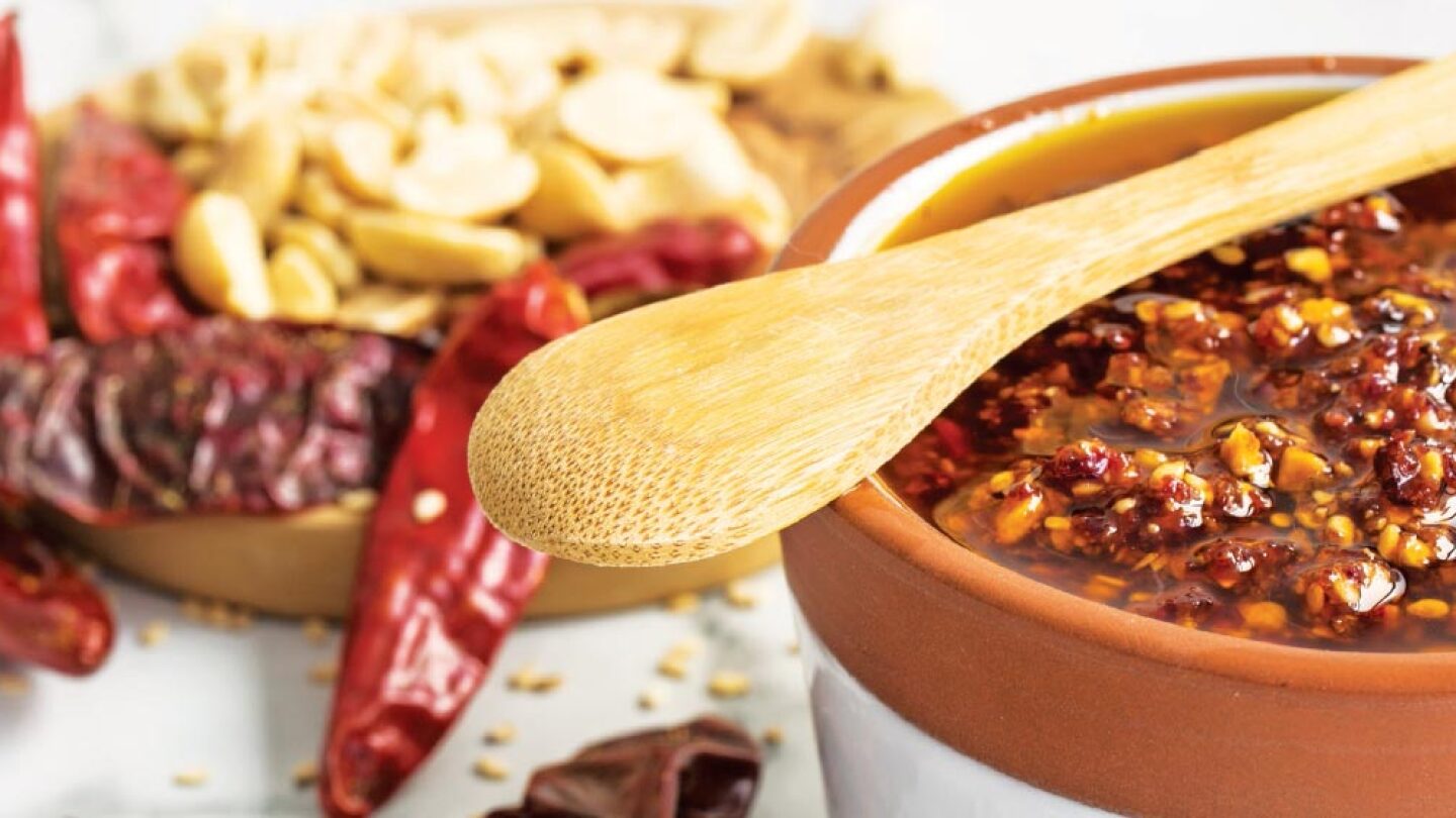 Un tazón de salsa macha con cacahuates y arándanos secos, lista para servir y destacar la receta.
