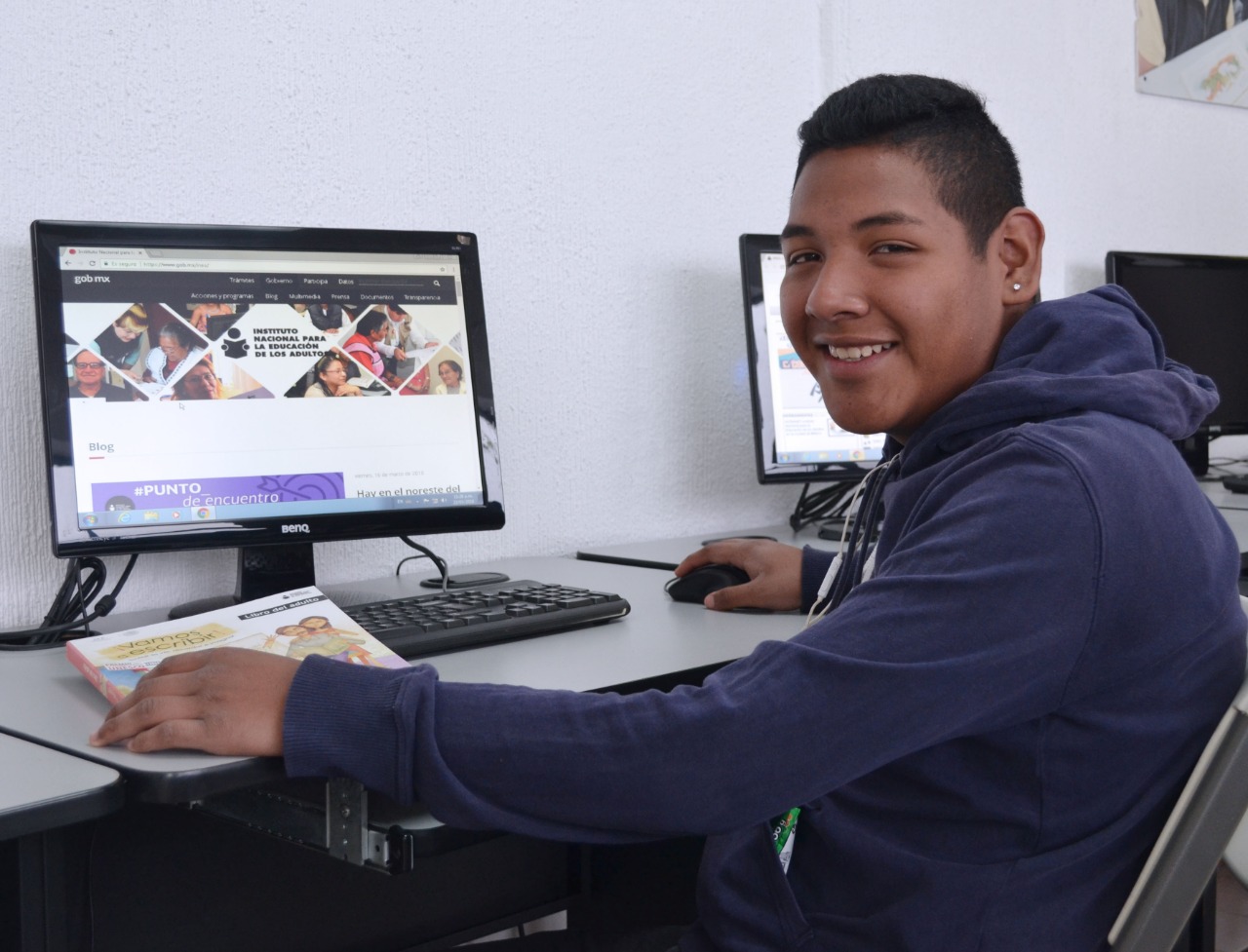 Persona adulta estudiando en línea en una computadora, representando la educación básica a distancia del INEA.