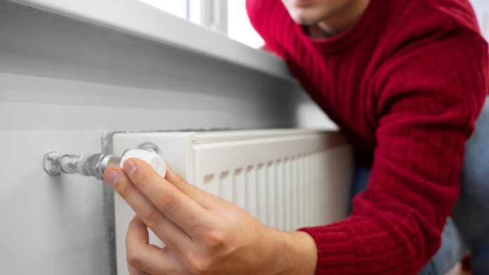 Persona ajustando un termostato inteligente, un consejo clave sobre cómo ahorrar gas en casa.