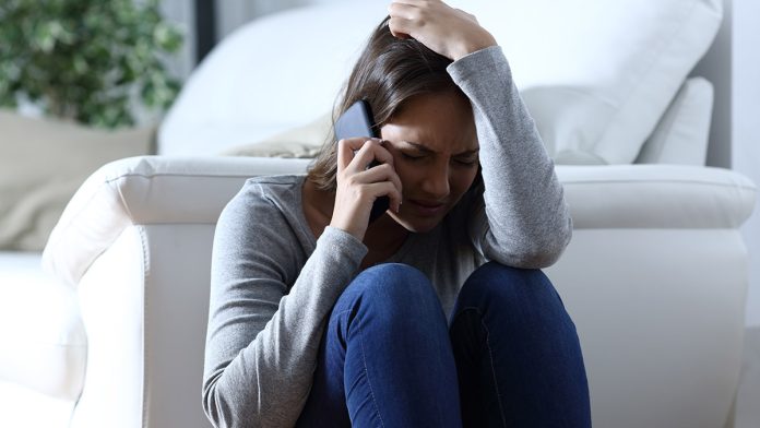 Persona hablando por teléfono con expresión de alivio, representando una línea de ayuda psicológica gratuita en México.