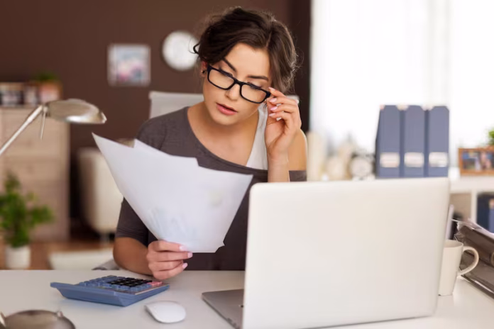 Una persona revisando su computadora con el portal del SAT de fondo, consultando cuánto tarda la devolución de su saldo a favor.