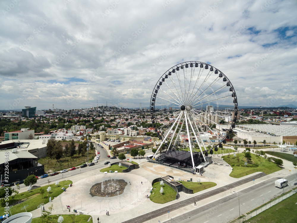 Vista panorámica de la ciudad de Puebla, mostrando la Catedral y la rueda de la fortuna, un lugar ideal para vivir.