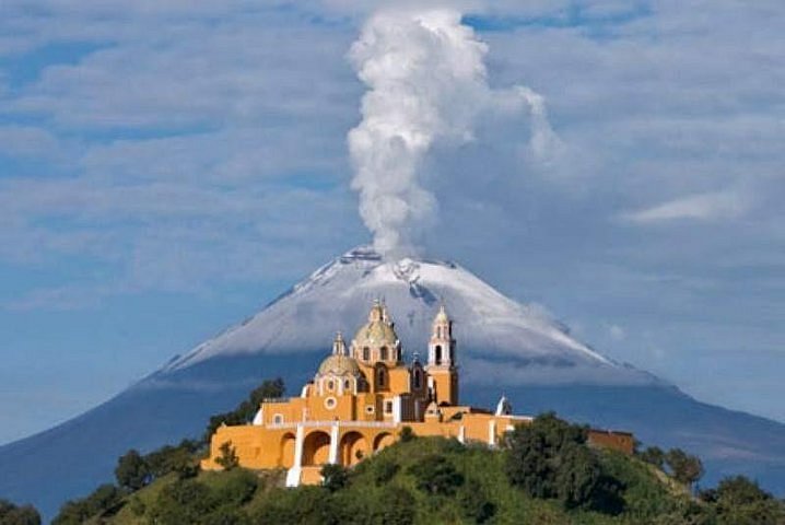 Vista panorámica de la pirámide de Cholula con la iglesia en la cima, uno de los mejores lugares para visitar cerca de Puebla.