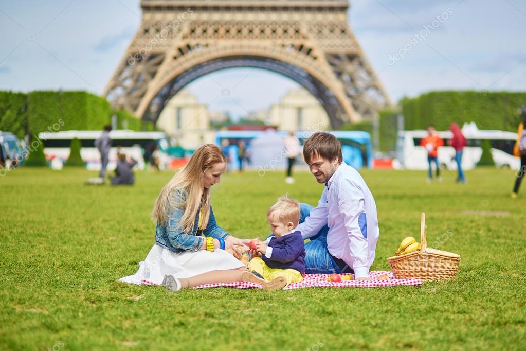 Familia disfrutando de un picnic en una de las playas artificiales en París, mostrando un día de ocio veraniego.