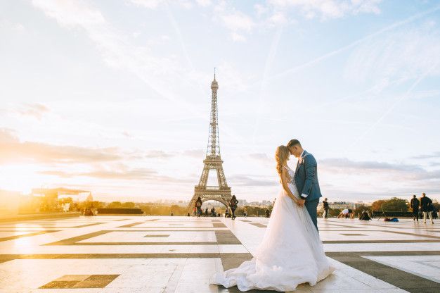 Pareja de recién casados abrazándose con la Torre Eiffel de fondo, simbolizando cómo casarse en París siendo extranjero.