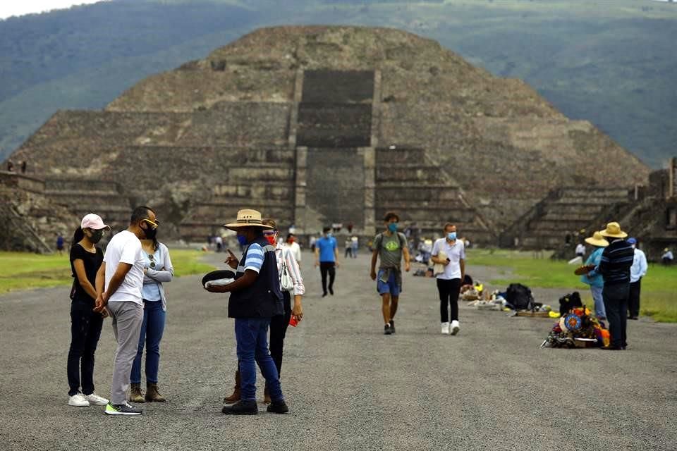 Turistas caminando por la Calzada de los Muertos en Teotihuacán, respetando las restricciones.