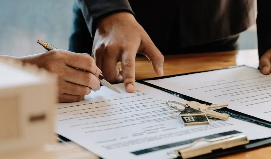 Una persona firmando los documentos para una hipoteca en Francia, un paso clave en el proceso de compra.