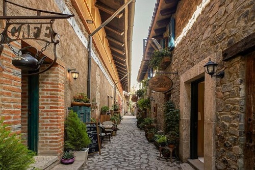 Vista de las calles empedradas y arquitectura de piedra en Val'Quirico, resaltando que la entrada es libre.