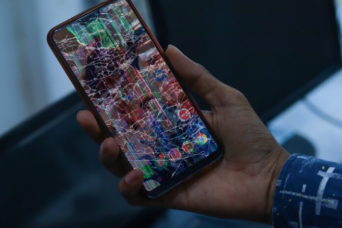 Celular con la pantalla rayada mostrando diferentes niveles de daño superficial.