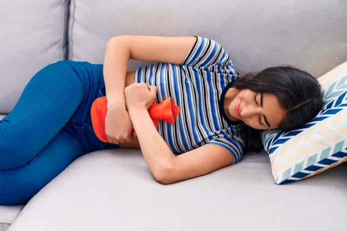 Mujer con dolor abdominal intenso buscando qué tomar para los cólicos menstruales muy fuertes.