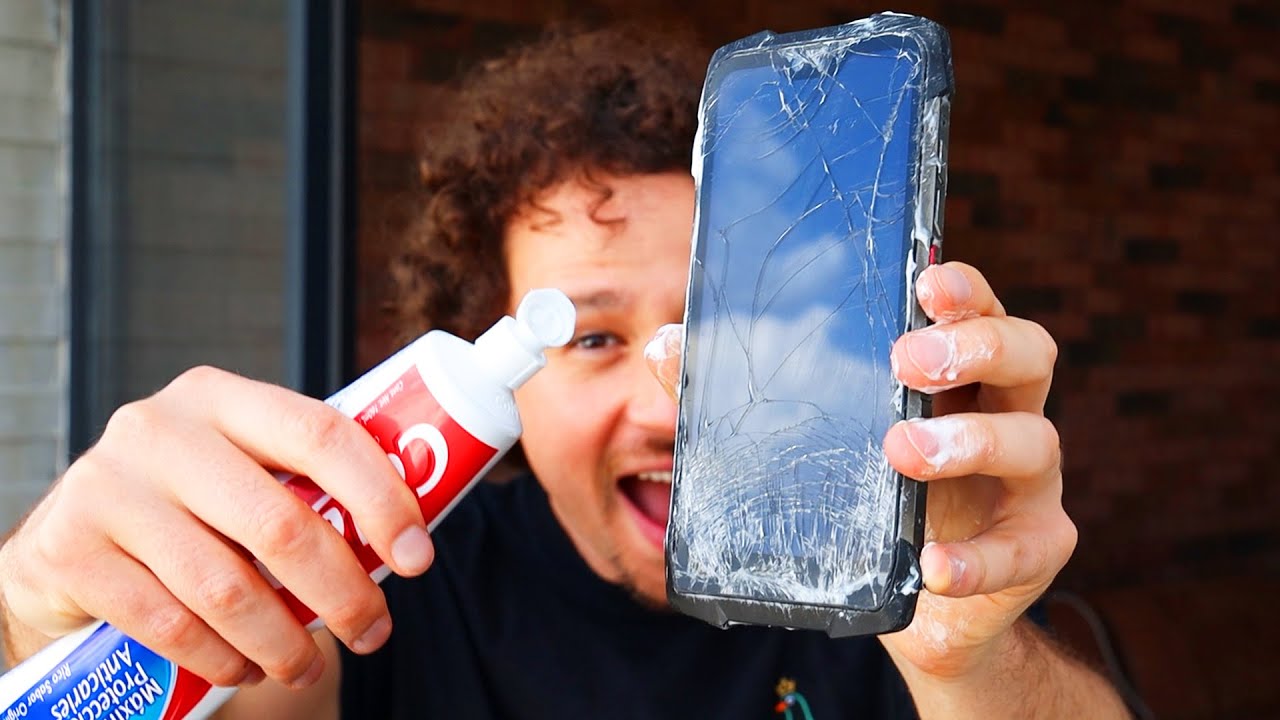 Persona aplicando pasta de dientes en un celular, un remedio casero popular pero riesgoso para pantallas rayadas.