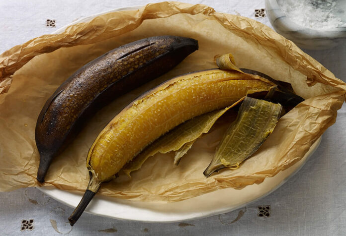 Plátanos con la cáscara negra recién salidos del horno en una bandeja para hornear.