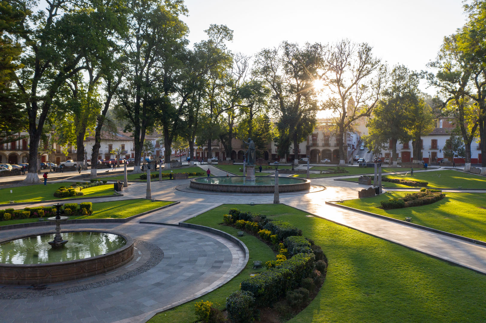 Plaza principal de Pátzcuaro Michoacán con fuente colonial y portal de artesanías purépechas durante festividades religiosas