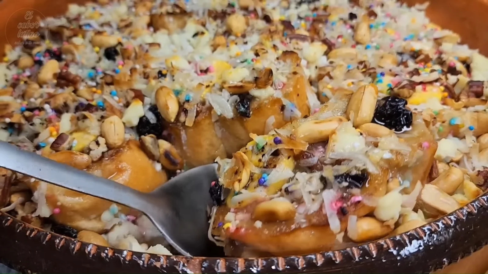 Proceso de armado de capirotada en refractario con capas de pan dorado queso rallado cacahuates pasas y plátano frito