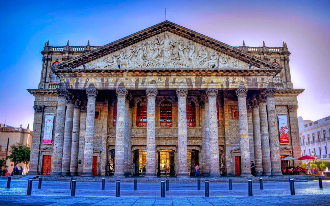 Teatro Degollado en Guadalajara con su fachada neoclásica y la fuente de los fundadores en primer plano durante el atardecer