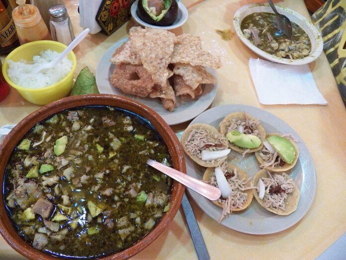 Pozole verde estilo Guerrero servido con pepita, lechuga y rabanitos